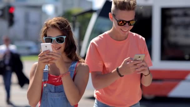 Gelukkige tiener paar met smartphones in de stad — Stockvideo