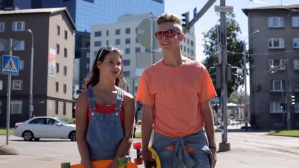 Teenage par med penny boards promenader i city — Stockvideo