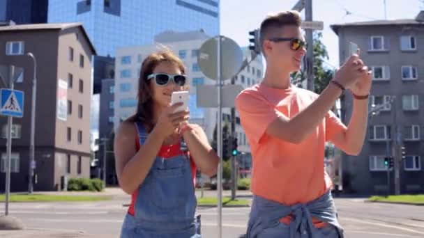 Heureux couple adolescent avec smartphones en ville — Video