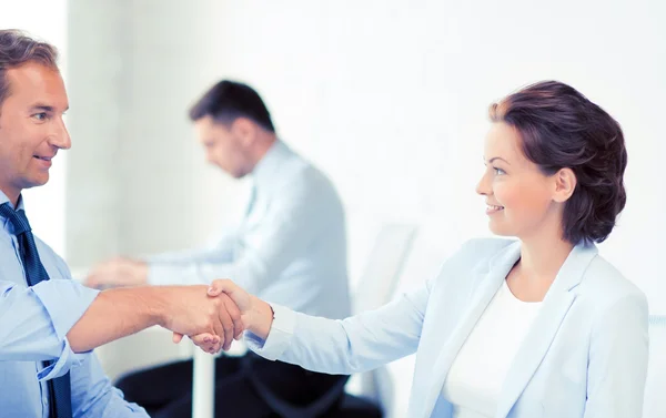 Man and woman shaking hands in office — Stock Photo, Image