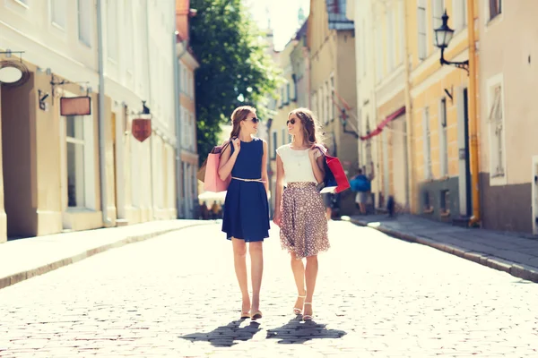 Glada kvinnor med påsar promenader i city — Stockfoto