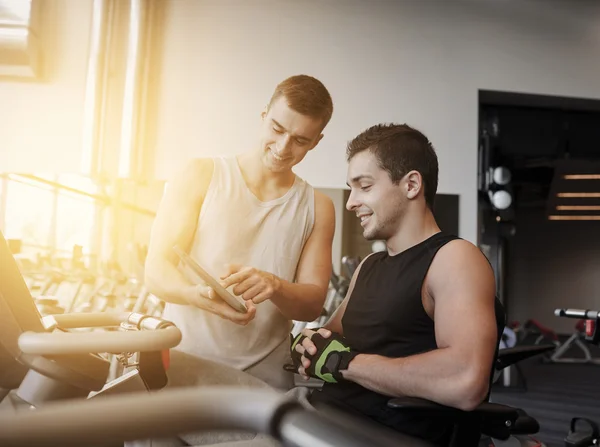 Men exercising on gym machine — Stock Photo, Image