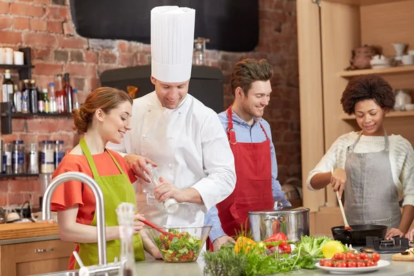 Amigos felices y cocinero cocinar en la cocina — Foto de Stock