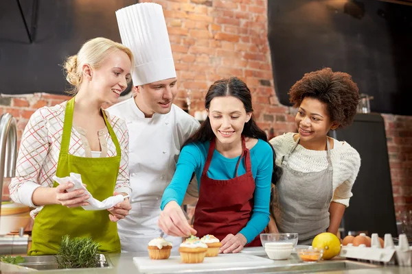 Mulheres felizes e cozinheiro chef assar na cozinha — Fotografia de Stock