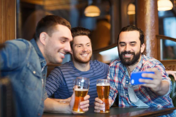 Друзья делают селфи и пьют пиво в баре — стоковое фото