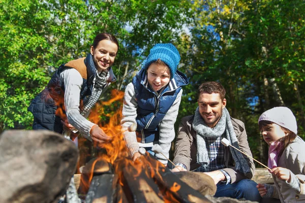 Familia feliz asado malvavisco sobre fogata — Foto de Stock