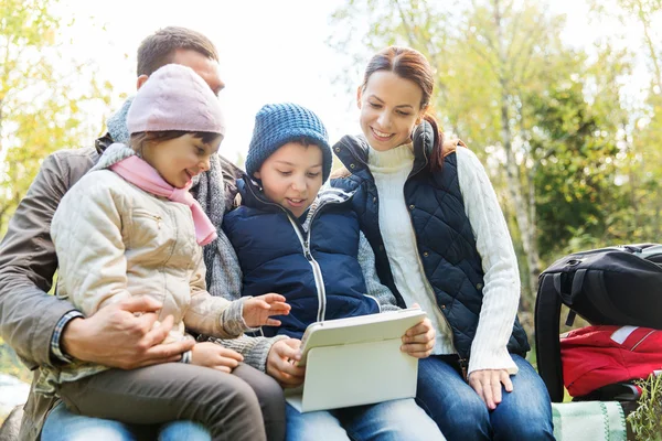 Famiglia felice con tablet pc e zaini al campo — Foto Stock