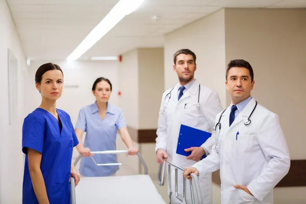 Groep van artsen met gurney in ziekenhuis — Stockfoto