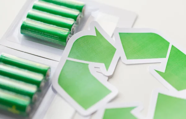 Close up of batteries and green recycling symbol — Stock Photo, Image