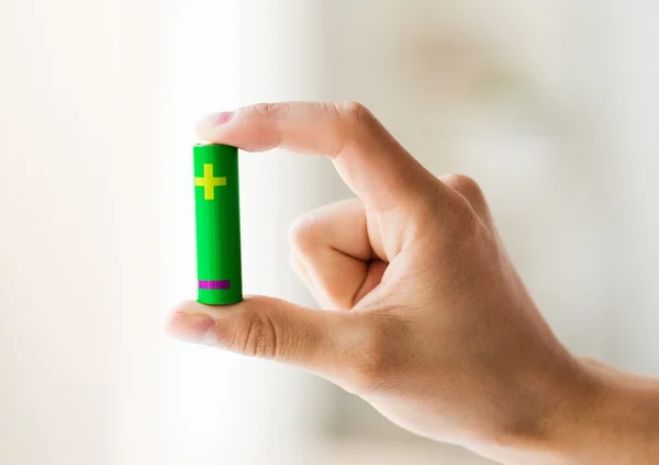 Close-up van de hand met groene alkaline batterij — Stockfoto