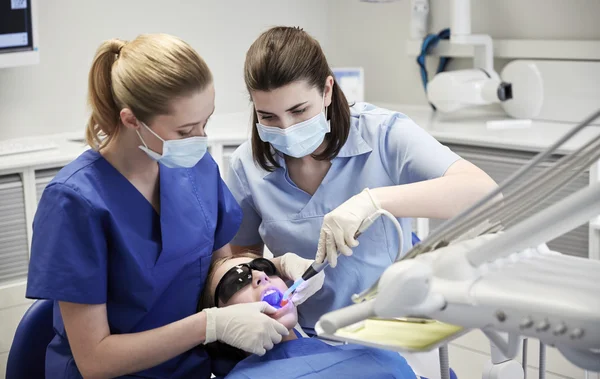 Dentistes féminines traitant les dents de fille patient — Photo