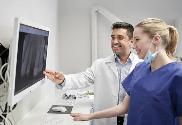 Dentistas com raio-x no monitor da clínica odontológica — Fotografia de Stock