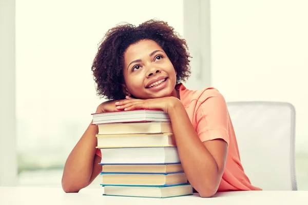 Chica estudiante africana feliz con libros en casa —  Fotos de Stock