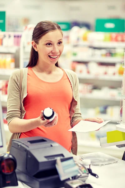 Mujer embarazada feliz con medicamentos en la farmacia —  Fotos de Stock