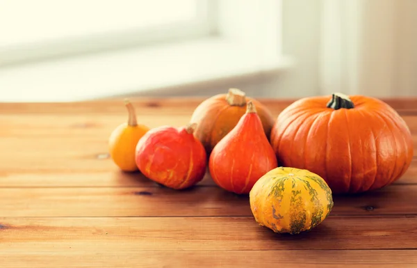 Close up of pumpkins on wooden table at home — Stock Photo, Image