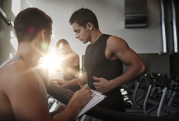 Män som tränar på löpband i gym — Stockfoto