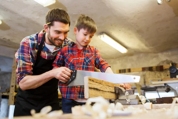 Father and son with saw working at workshop — Stock Photo, Image
