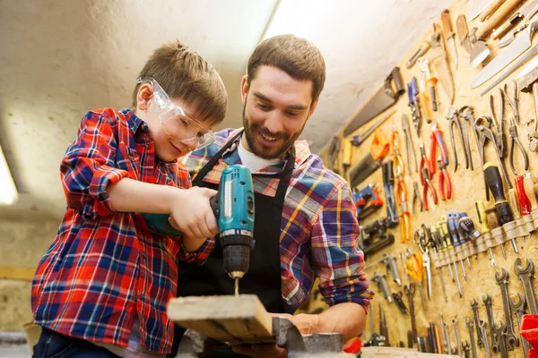 Pai e filho com broca trabalhando na oficina — Fotografia de Stock