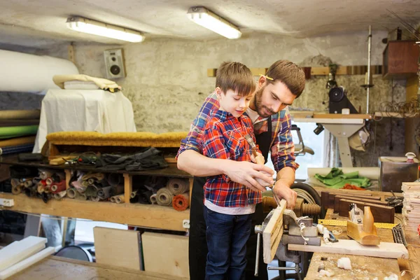 Отец и сын с зубилом работают в мастерской — стоковое фото