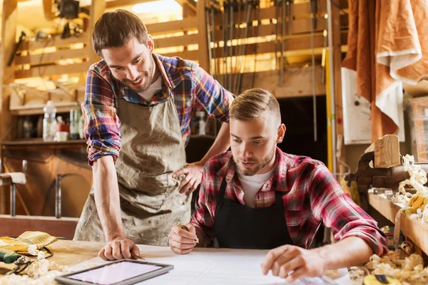 Operai con tablet pc e cianografia in officina — Foto Stock