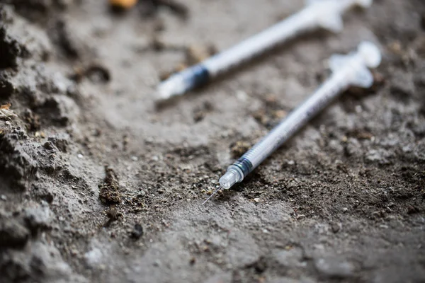 Primer plano de las jeringas de drogas usadas en el suelo — Foto de Stock