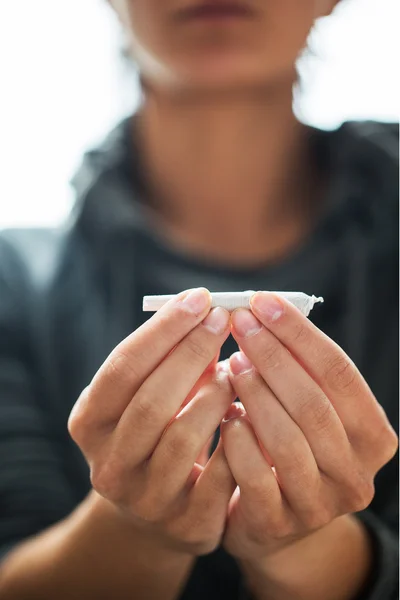 Perto de mãos viciadas com maconha conjunta — Fotografia de Stock