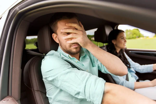 Woman driving car and man covering face with palm — Stock Photo, Image