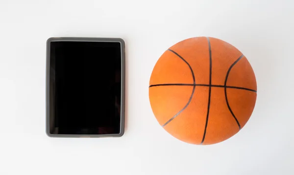 Lähikuva koripallo ja tabletti tietokone — kuvapankkivalokuva