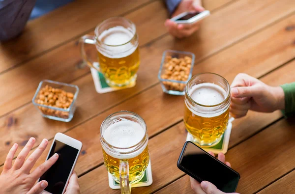 Yakın el ile akıllı telefonlar ve bira bar — Stok fotoğraf