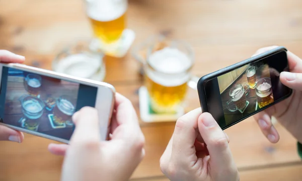 Nahaufnahme der Hände mit dem Smartphone, das Bier zeigt — Stockfoto