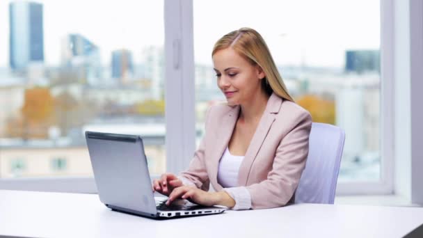 Joven mujer de negocios con computadora portátil escribiendo en la oficina — Vídeos de Stock