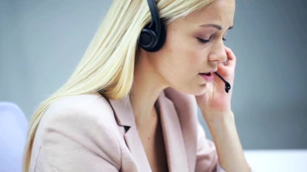 Mujer de negocios con auriculares hablando en la oficina — Vídeo de stock