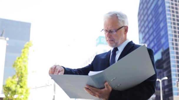 Senior businessman with ring binder folder in city — Stock Video