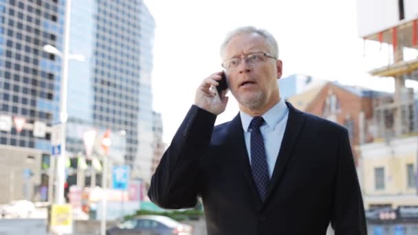 Senior zakenman belt op smartphone in de stad — Stockvideo