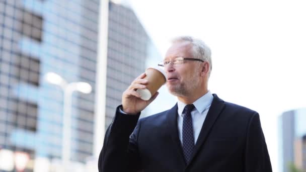 Старший бизнесмен пьет кофе на городской улице — стоковое видео