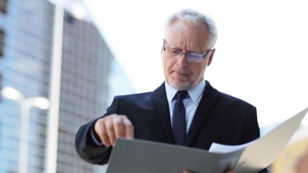 Senior businessman with ring binder folder in city — Stock Video