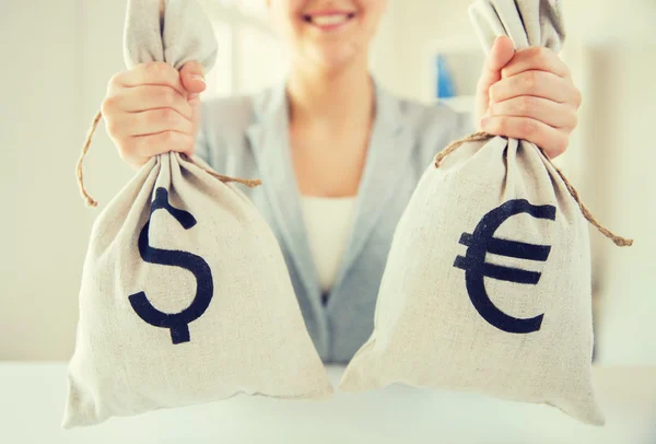 Close up of woman hands holding money bags — Stock Photo, Image