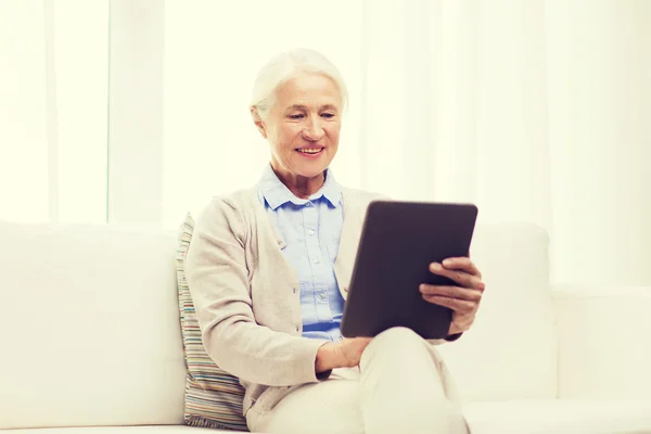 Gelukkig senior vrouw met tablet pc thuis — Stockfoto