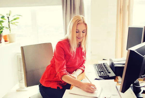 Kreative Frau schreibt im Büro ans Notizbuch — Stockfoto