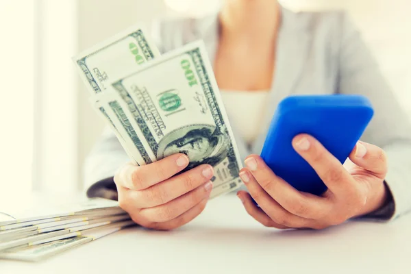 Primo piano delle mani della donna con smartphone e denaro — Foto Stock