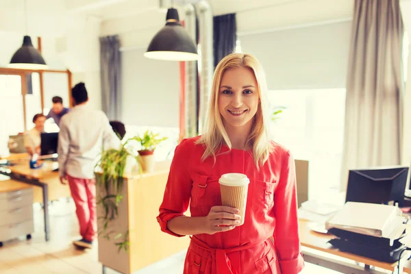 Mujer creativa feliz con taza de café en la oficina —  Fotos de Stock