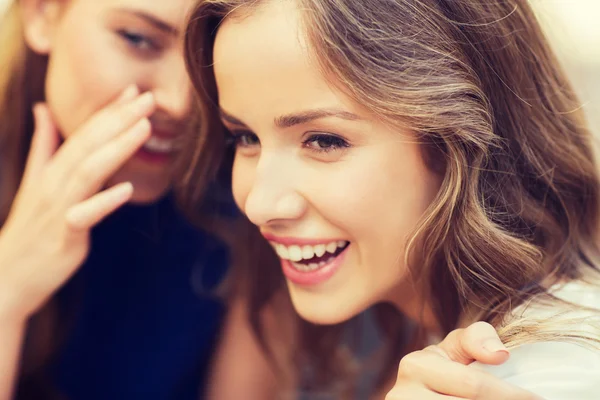 Souriantes jeunes femmes bavardant et chuchotant — Photo