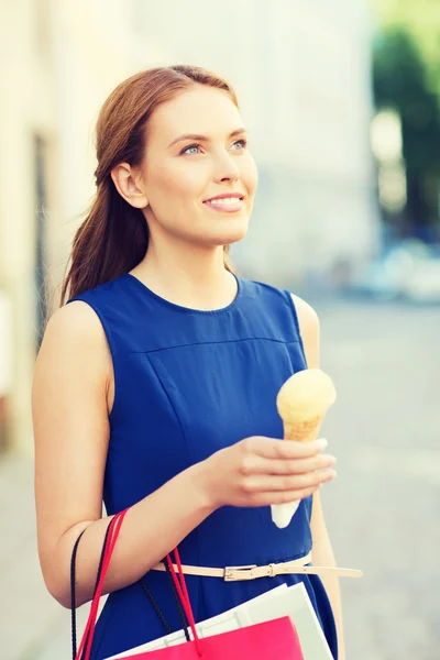 Frau mit Einkaufstüten und Eis in der Stadt — Stockfoto