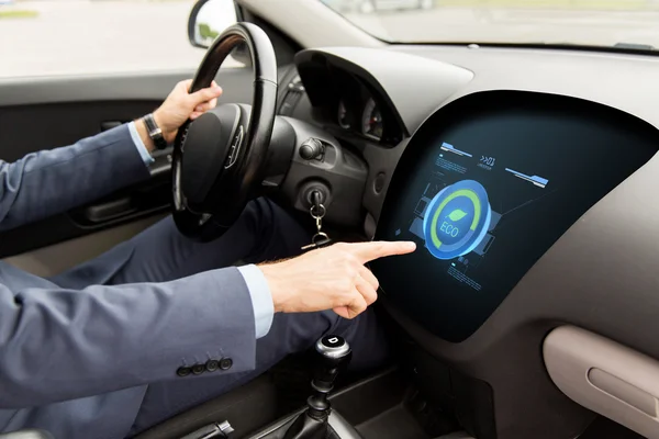 Man driving car with eco mode on board computer — Stock Photo, Image