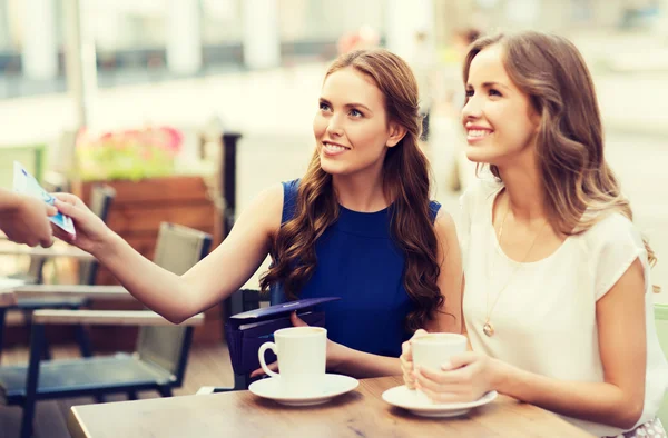 Women paying money to waiter for coffee at cafe — Stock Photo, Image