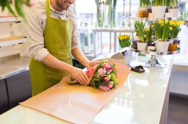 Floristería envolviendo flores en papel en floristería — Foto de Stock