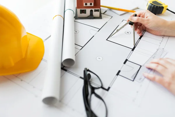 Close up of hands with compass measuring blueprint — Stock Photo, Image