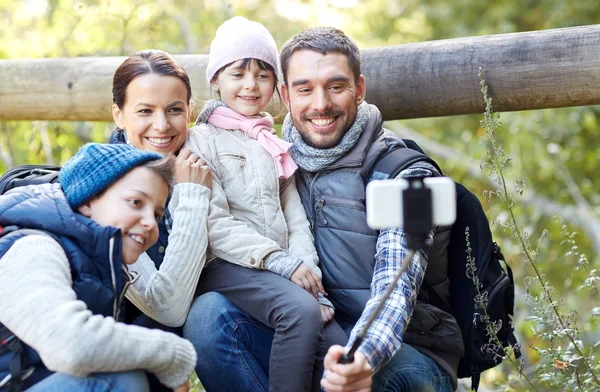 Família feliz com vara selfie smartphone na floresta — Fotografia de Stock