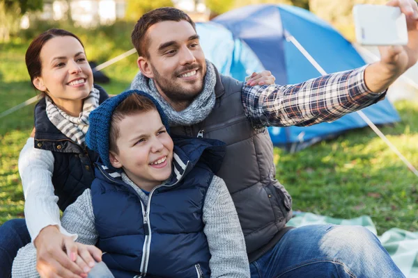 Family with smartphone taking selfie at campsite — Stock Photo, Image