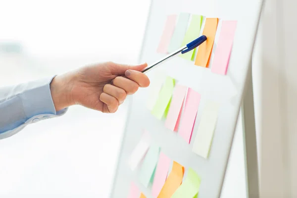 Close up of hand pointing to sticker on flip chart — Stock Photo, Image